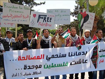 Palestinians carry a banner: we will shield unity with our lives. (Aljazeera)